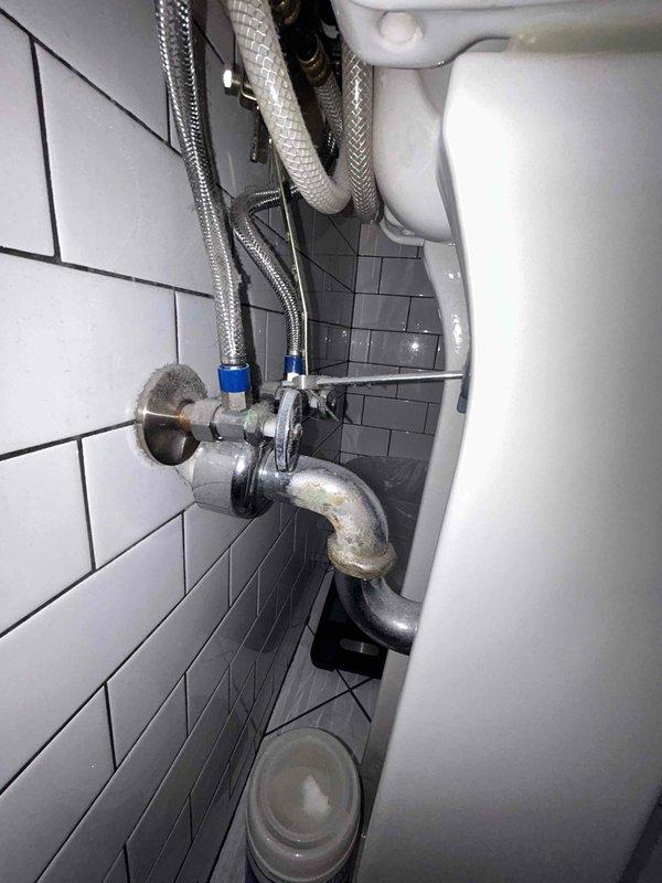 Completed routine plumbing inspection of bathroom fixtures with focus on shower installation and toilet connections. Examined shower system components including diverter valve, fixed showerhead, and handheld unit, all in working order. Noted minor corrosion on toilet supply line connection at wall penetration that should be monitored but currently maintains proper seal with no active leaks detected.