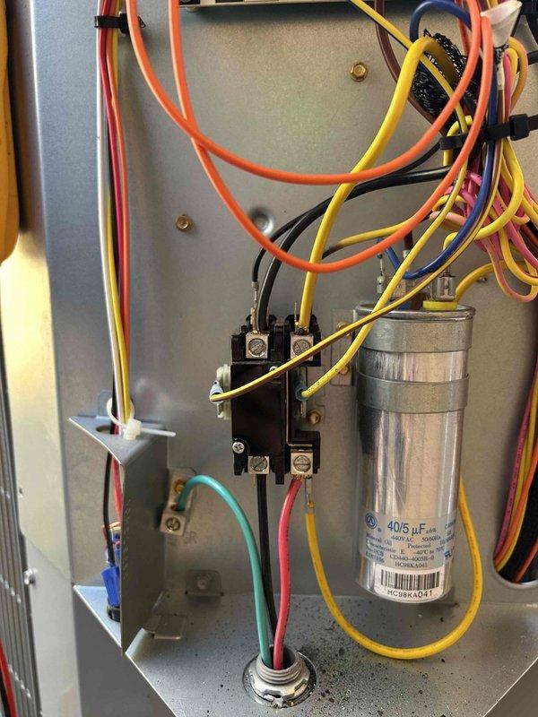 Diagnosed AC system less than one year old that was not cooling or heating after recent maintenance. Visual inspection of electrical control panel showed all components in normal working condition with no visible damage to capacitor (40/5 μF), contactor, or wiring connections. System was restored to proper operation by verifying electrical connections and cycling power to reset the control board.