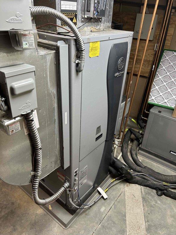 Responded to service call for 26-year-old HVAC system shutting down with E71 error code (loss of charge). Diagnostic inspection of the IntelliZone2 thermostat revealed loss of signal notification and system operating in humidity mode with fan engaged. Examination of the basement air handler unit showed significant age-related wear requiring refrigerant recharge to restore proper functionality.