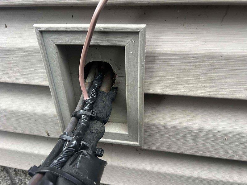 Inspected home's HVAC exterior line set and electrical connections at the utility chase where wires enter the structure. Secured loose wiring with new zip ties and applied proper weatherproofing to prevent animal intrusion and potential wire damage. Ensured all connections were properly sealed and protected against environmental exposure.