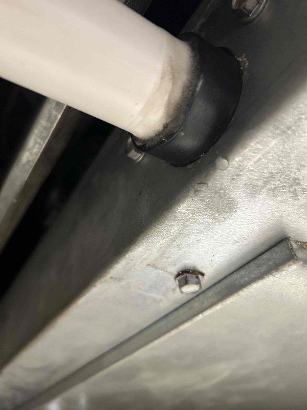 Responded to commercial water leak service call for ceiling-mounted HVAC unit with steady drip. Identified compromised connection between condensate drain line and unit, where rubber coupling showed signs of deterioration. Replaced damaged coupling and verified proper drainage function, eliminating the active leak.
