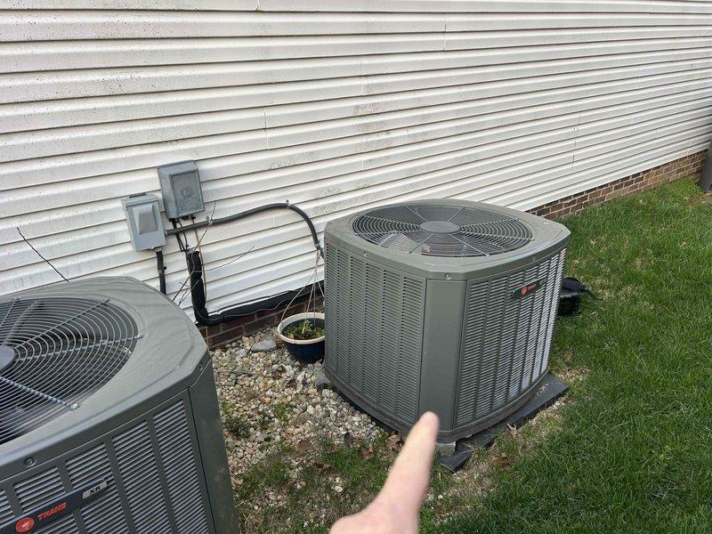 Responded to a non-urgent cooling issue where the system was unable to cool below 74°F despite a 70°F setpoint. Inspection of the dual outdoor condenser units revealed normal installation on proper gravel beds with appropriate electrical connections. Thermostat inspection showed the Honeywell ProSeries was functioning correctly but was set to "Heat On" mode rather than cooling mode, explaining the temperature discrepancy. Adjusted system settings and verified proper operation with the homeowner.