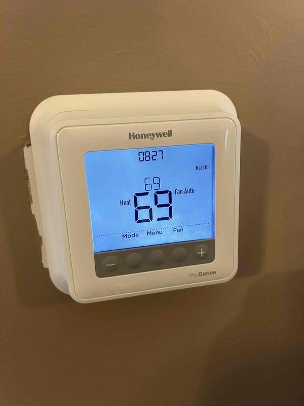 Responded to a non-urgent cooling issue where the system was unable to cool below 74°F despite a 70°F setpoint. Inspection of the dual outdoor condenser units revealed normal installation on proper gravel beds with appropriate electrical connections. Thermostat inspection showed the Honeywell ProSeries was functioning correctly but was set to "Heat On" mode rather than cooling mode, explaining the temperature discrepancy. Adjusted system settings and verified proper operation with the homeowner.