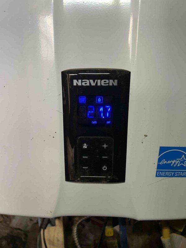 Responded to no-heat service call for a Navien boiler displaying error code 302. Diagnosed deteriorated mechanical component with visible wear and debris accumulation within the boiler housing. Reset system controls and verified proper operation with temperature reading restored to 21.7°C as shown on the control panel.