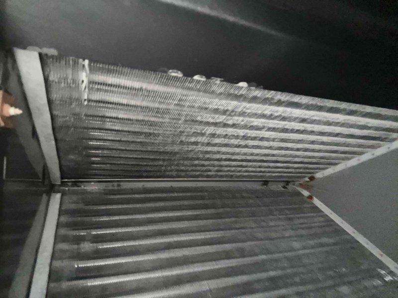 Performed diagnostic assessment on dual HVAC units per customer's high energy bill concerns. Inspection revealed significant dust accumulation on evaporator coils affecting system efficiency. Measured and documented ductwork dimensions (approximately 25") to evaluate proper airflow. Recommended standard cleaning of coils and filter replacement to improve system performance and reduce energy consumption, which should address the intermittent red indicator light issues.