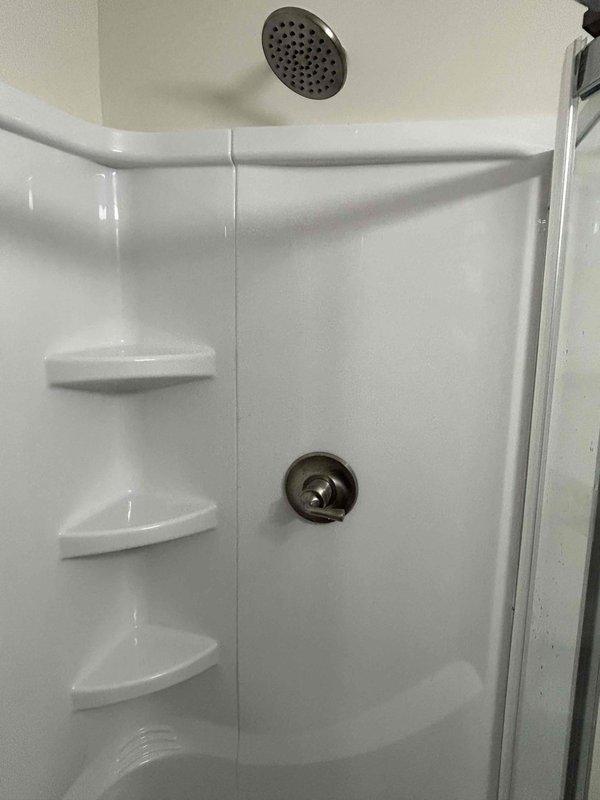 Completed final phase of utility room installation, including connection and mounting of stainless steel sink with chrome faucet to the metal cabinet, as well as installation of shower stall fixtures including ceiling-mounted showerhead and wall-mounted water control handle. All plumbing connections were properly sealed and tested for functionality after drywall, painting, and flooring work had been completed by others.