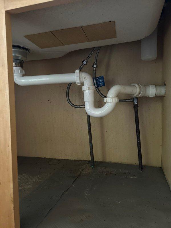 Responded to service call for clogged sink. Inspected basement plumbing system with PVC drainage pipes and under-sink P-trap configuration. Successfully cleared blockage and verified proper drainage function, ensuring system returned to normal working condition.