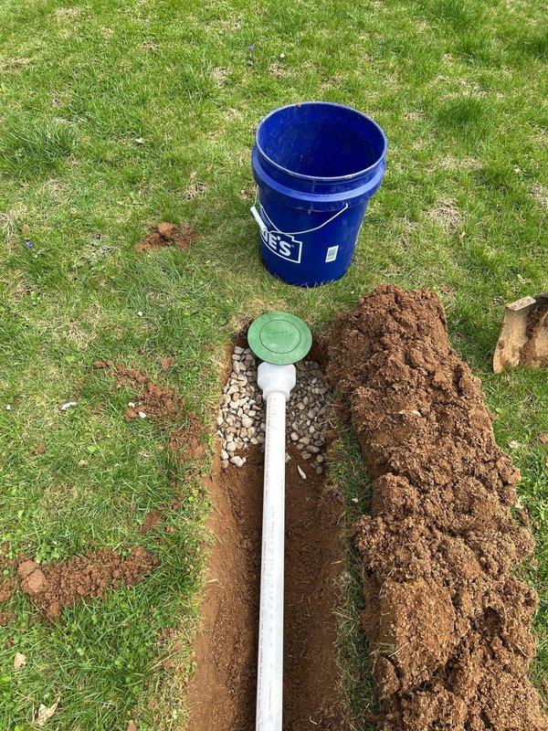 Successfully removed existing sump pump from sewer line and relocated approximately 30ft away from the residence. Excavated trenches in yard, installed PVC discharge pipe with proper drainage materials, and positioned pump to direct water flow away from foundation as requested.