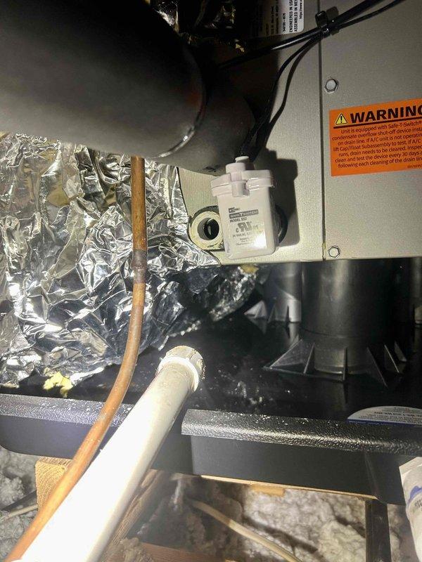 Responded to water leak complaint from HVAC system. Inspected attic unit where condensate drain system showed signs of previous repair attempts with visible white sealant residue around drain connections. Identified faulty condensate pump and compromised drain line as source of recurring leakage. Repaired connections and verified proper drainage operation.