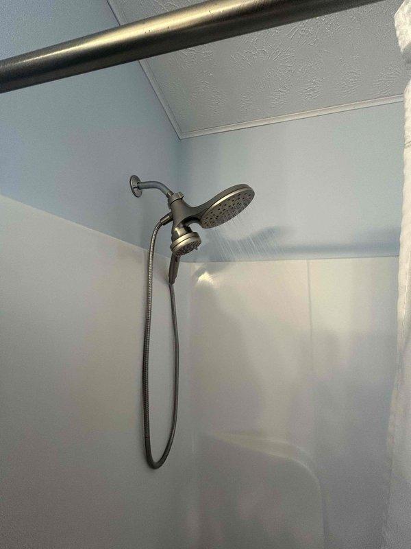 Performed comprehensive 60-point inspection and completed tankless water heater flush service. Verified proper water flow and pressure through both fixed rainfall showerhead and handheld shower component. All fixtures functioning normally with no visible leaks, damage, or mineral buildup detected.