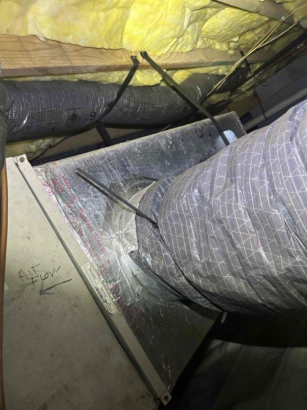 # Service Report: HVAC No Cool Diagnosis

Responded to service call for heat pump system blowing room temperature air with no cooling for several days. Customer provided remote access to property. 

Upon arrival, located air handler in attic space and conducted system inspection. Documented existing installation including ductwork, insulation, and mechanical components. Examined refrigerant lines, electrical connections, and system controls. 

Inspected condensing unit components and noted visible corrosion and rust staining on motor housing and mounting points. Observed deteriorated condition of electrical connections and wiring harnesses. Refrigerant piping showed signs of age and wear. System components displayed accumulation of dirt and oxidation consistent with lack of preventive maintenance.

Photographed equipment conditions for documentation purposes. Based on visual inspection findings, system requires comprehensive diagnostic testing to determine specific component failure ca