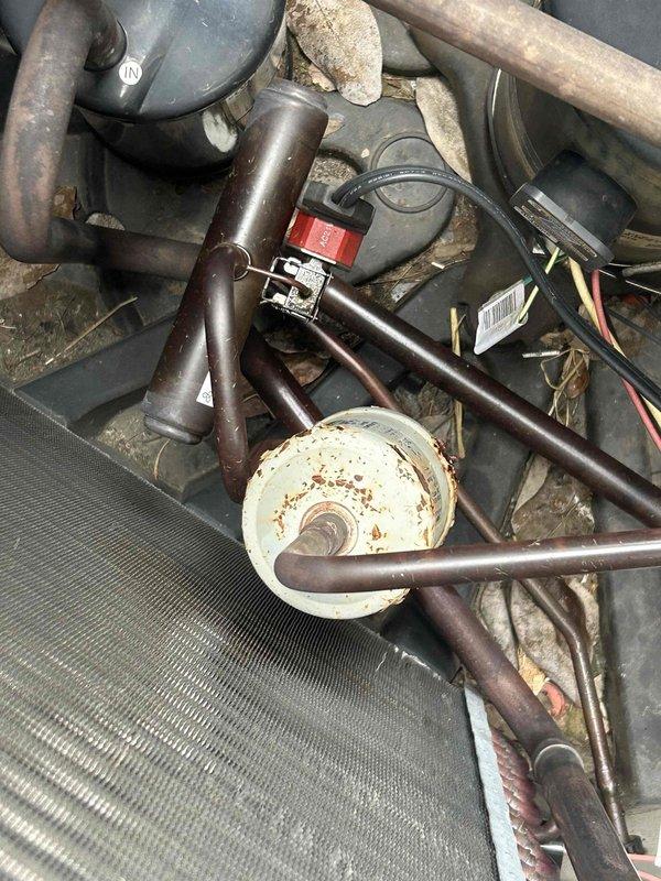# Service Report: HVAC No Cool Diagnosis

Responded to service call for heat pump system blowing room temperature air with no cooling for several days. Customer provided remote access to property. 

Upon arrival, located air handler in attic space and conducted system inspection. Documented existing installation including ductwork, insulation, and mechanical components. Examined refrigerant lines, electrical connections, and system controls. 

Inspected condensing unit components and noted visible corrosion and rust staining on motor housing and mounting points. Observed deteriorated condition of electrical connections and wiring harnesses. Refrigerant piping showed signs of age and wear. System components displayed accumulation of dirt and oxidation consistent with lack of preventive maintenance.

Photographed equipment conditions for documentation purposes. Based on visual inspection findings, system requires comprehensive diagnostic testing to determine specific component failure ca
