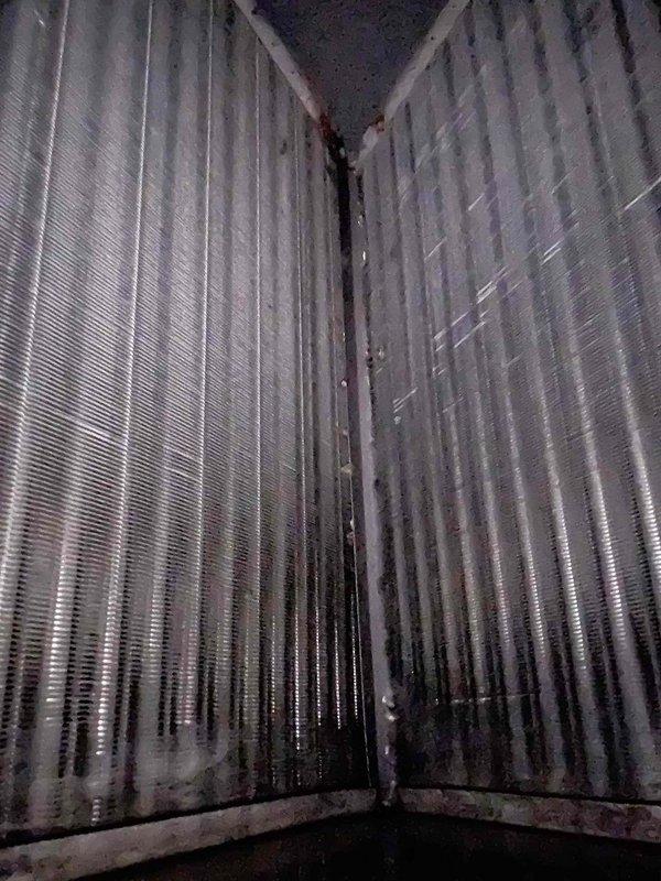 # HVAC Maintenance - Club Single Service Completed

Performed comprehensive preventive maintenance tune-up on heat pump and air handler system located in basement. Conducted electrical diagnostics using clamp meter, recording amperage draw of 16.3 amps on system components to verify proper operation within manufacturer specifications. Inspected electrical connections, capacitor, and control wiring for signs of wear or deterioration.

Thoroughly examined evaporator coil assembly and identified significant contamination with dark staining and moisture-related buildup on lower portions of finned surfaces, indicating accumulated dirt, debris, and possible microbial growth. This condition can restrict airflow, reduce system efficiency, and impact indoor air quality. Documented coil condition with photographic evidence for service records.

Completed standard maintenance checklist including inspection of all accessible system components, electrical connections, and operational parameters. Cu