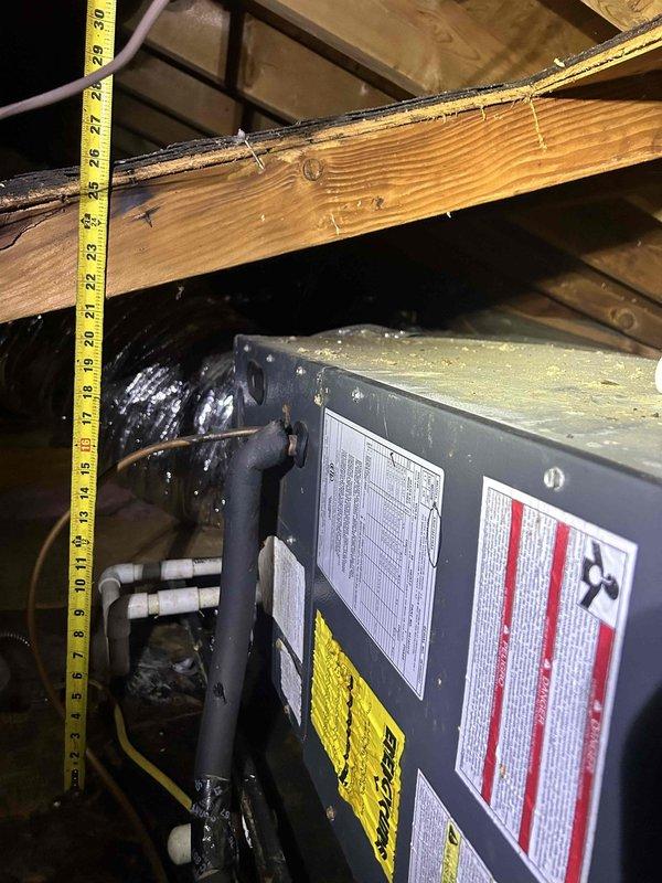 Responded to no cooling complaint on 15-year-old electric heat pump system located in attic space above home addition. Upon inspection, found air handler blowing ambient temperature air with no refrigerant cooling. Accessed indoor unit compartment and discovered severely deteriorated evaporator coil insulation that had expanded and separated from coil assembly, indicating prolonged moisture exposure and potential refrigerant leak. Observed copper refrigerant lines with oxidation and filter drier showing signs of age-related degradation. Documented equipment condition with photographs showing compromised insulation material, evaporator coil assembly, and refrigerant line connections. Given the age of the system and extent of component deterioration, provided customer with diagnostic findings and repair options including coil replacement versus full system replacement recommendations.