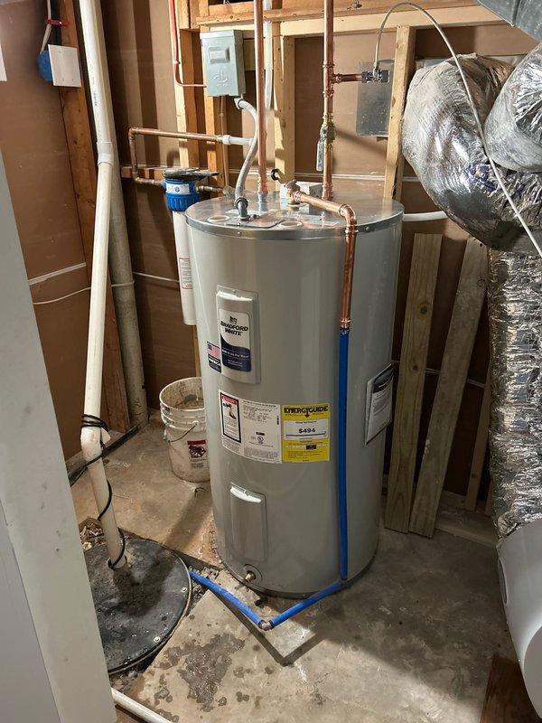 Completed installation of a new 50-gallon electric Bradford White water heater in an unfinished utility space. Positioned unit on concrete floor, connected copper supply and discharge lines with proper fittings, installed electrical conduit and wiring to power the unit, and integrated white PVC drain piping for temperature and pressure relief valve discharge. All connections were secured and tested to ensure proper operation and compliance with plumbing codes.