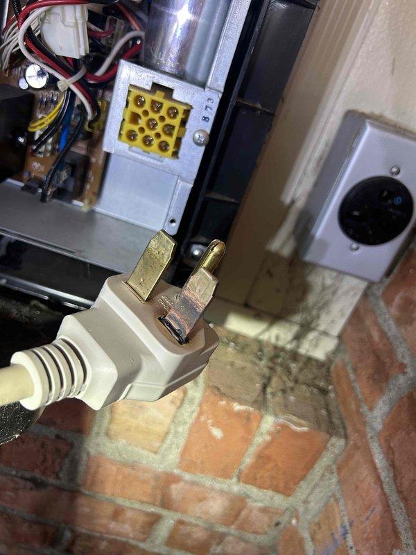 # HVAC Service Report - Mini Split No Power

Responded to service call for 12-year-old mini split system in sunroom with no power condition. Upon arrival, found unit completely non-operational with no response from controls. Inspection revealed compromised 250-volt dedicated outlet with evidence of significant electrical degradation, water intrusion damage, and heavy staining on surrounding surfaces beneath the receptacle. Outlet showed signs of long-term environmental exposure consistent with sunroom installation. Documented electrical connection points, terminal block configuration, and power supply components. Unit's age and electrical supply condition indicate need for further evaluation of power delivery system and potential component replacement to restore operation.