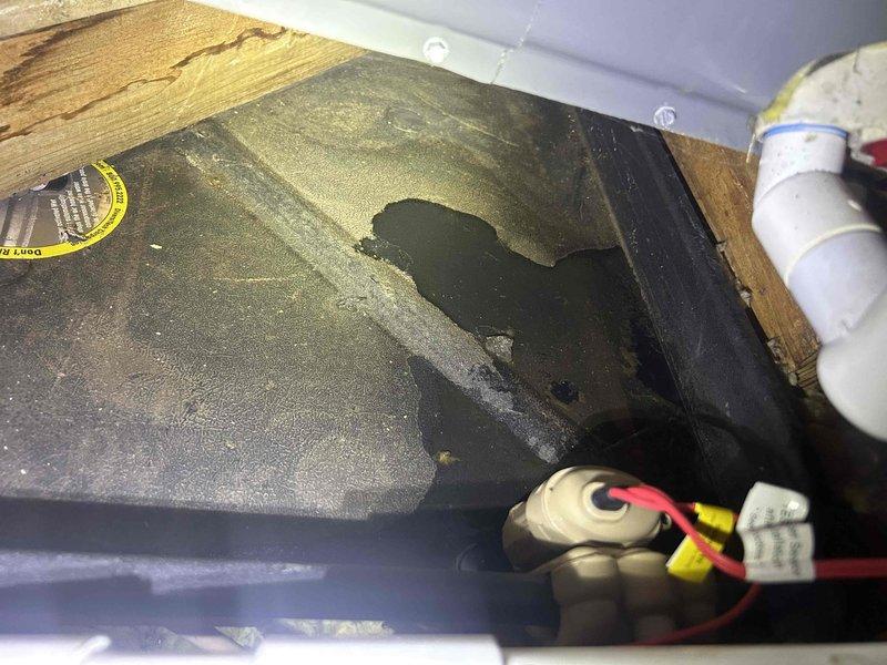 Responded to no cooling complaint on 7-year-old electric furnace and air conditioning system with air handler located in attic. Upon inspection, found system blowing room temperature air with no refrigerant circulation. Accessed interior components of air handler and outdoor condensing unit to perform diagnostic evaluation. Identified accumulation of dust and debris on interior panels indicating inadequate filtration and possible airflow restrictions. Inspected evaporator coil assembly, refrigerant lines, condensate drainage system, and electrical connections. Documented condition of gas valve assembly, control board, and associated wiring harnesses. Photographed interior components showing yellow insulated suction line, copper refrigerant piping, and cabinet conditions for service records and further assessment of cooling system failure.