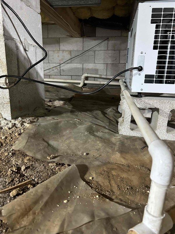 Installed Aprilaire E080 whole-house dehumidifier system in crawlspace as a stand-alone, non-ducted unit with 80-pint daily moisture removal capacity. Unit was mounted on concrete blocks for proper elevation and clearance, with built-in digital control panel configured for automatic humidity sensing. System includes condensate drainage line routed to appropriate discharge point to prevent moisture accumulation and protect against mold, wood rot, and structural damage.