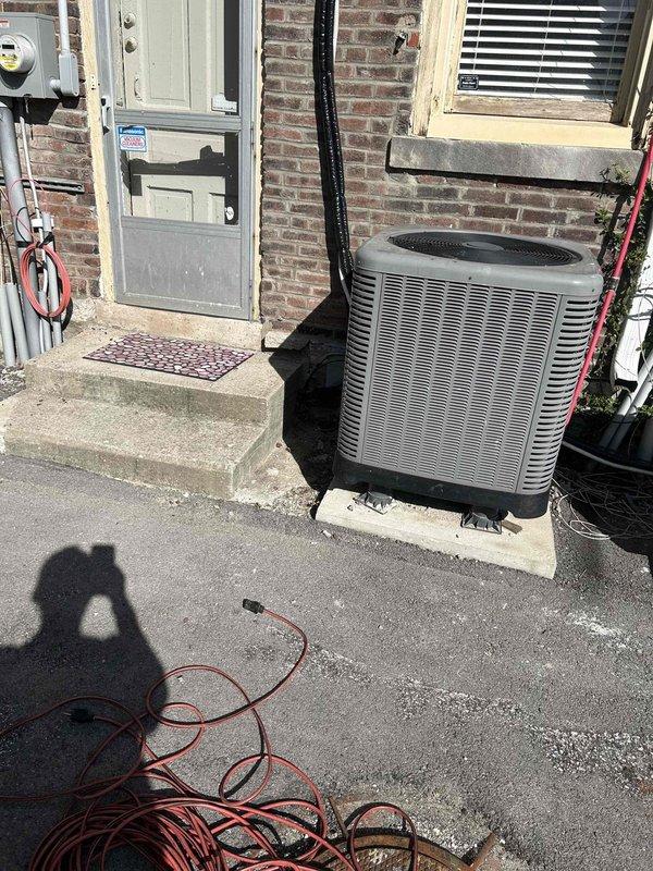 Completed residential installation of Durastar 18,000 BTU mini-split system consisting of model DRAW18F2A wall-mounted indoor unit and model DRA1U18S2A outdoor condensing unit. Indoor air handler was mounted on interior wall between two windows per specifications, while outdoor unit was positioned on concrete pad at ground level on rear exterior wall. Line set was secured vertically along exterior brick wall without line hide cover, with press fittings utilized for indoor unit connections in place of standard flares and Nyc-log sealant applied to outdoor unit flare threads. New dedicated electrical circuit was installed to power the system. System was pressure tested, evacuated, charged, and commissioned to manufacturer specifications. All equipment tested and verified operational upon completion.