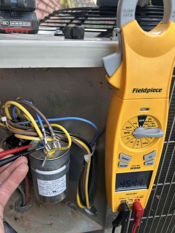 Completed preventative maintenance tune-up on air conditioning unit and gas furnace system located in closet. Performed comprehensive electrical diagnostics using digital multimeter, measuring capacitor performance at 363.0 microfarads to verify proper compressor operation. Tested supply air temperature at register, recording 33.4°F to confirm adequate cooling capacity and system efficiency. All electrical connections inspected and found secure, with capacitor terminals properly connected and functioning within specifications.