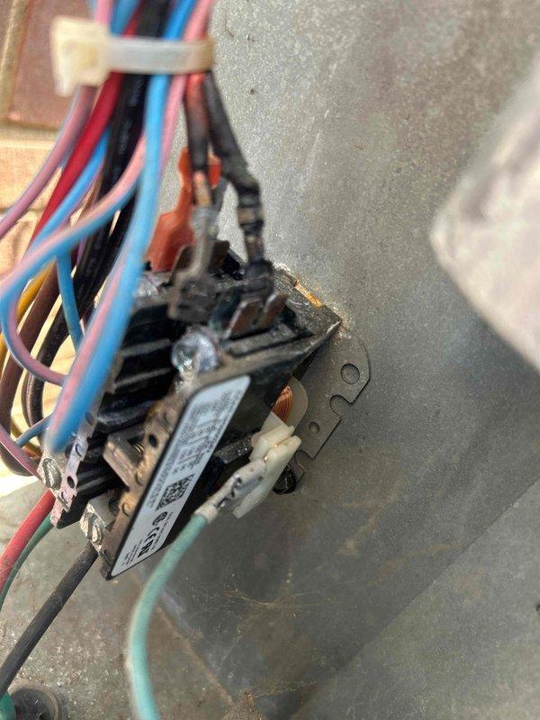 Responded to no cooling call on electric HVAC system with indoor unit located in basement. Upon inspection, discovered failed contactor relay with severe heat damage, corrosion, and charring around terminals and mounting area. Evidence of electrical arcing and thermal deterioration indicated component failure preventing compressor operation. Replaced defective contactor relay, verified all wire connections secure, and tested system operation. Unit cooling properly upon departure.