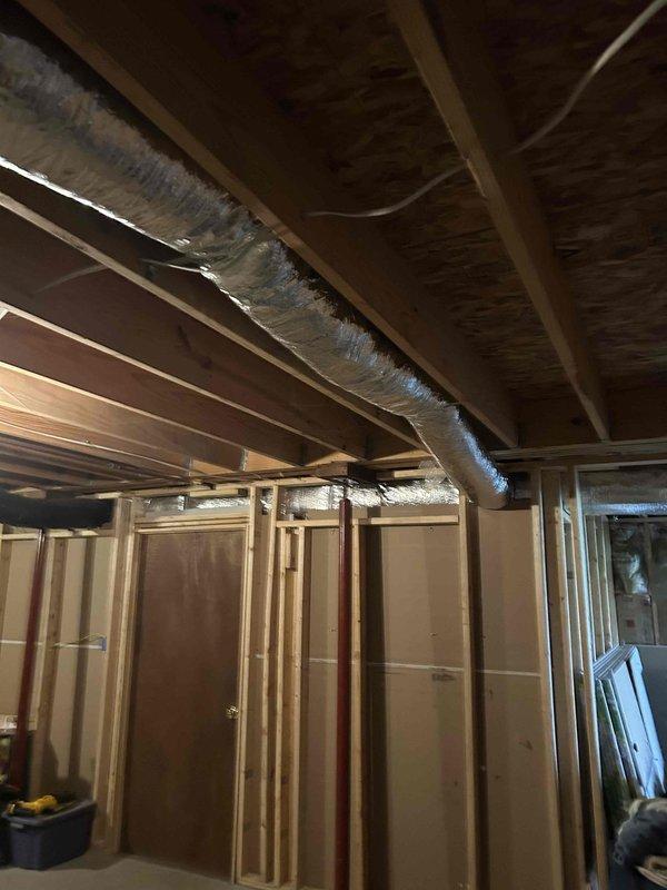 Replaced a damaged 6-inch flexible duct run with new R6 insulated flex ductwork in the basement area. The installation was completed in the unfinished space with exposed ceiling joists, ensuring proper support and connection to the existing HVAC system to restore efficient airflow.