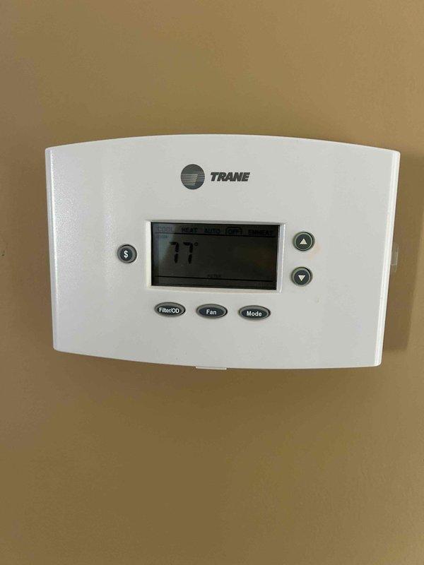 # HVAC Service Call - No Cooling Condition

Responded to service call for 9-year-old residential air conditioning system with complete loss of cooling and heating functionality. Customer reported outdoor AC unit not operational.

## Diagnostic Procedures

Upon arrival, performed comprehensive system evaluation beginning with thermostat functionality check. Confirmed Trane thermostat displaying 77°F and verified proper power supply to control board. Tested thermostat communication with system components and confirmed display responding to input commands.

Proceeded to outdoor condensing unit inspection. Conducted visual assessment of compressor, condenser fan motor, and electrical connections. Verified power supply at disconnect and measured voltage at contactor. Tested capacitor values using multimeter to determine if dual-run capacitor within acceptable microfarad range.

Accessed attic-mounted air handler unit for indoor component evaluation. Inspected blower motor operation, evapora