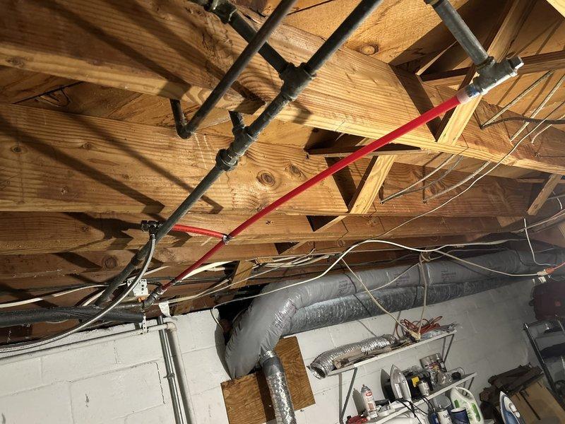 Responded to a leaking pipe issue in a seventy-year-old residential property. Upon arrival, conducted a thorough inspection of the plumbing system in the basement and attic utility areas. Located the source of the leak affecting a section of aging cast iron pipe that showed significant deterioration and corrosion consistent with the age of the home's original plumbing infrastructure.

Assessed the existing pipe configuration, which included a combination of older black iron piping and newer PVC connections. The leak originated from a compromised section where metal pipe showed advanced weathering and structural weakness. Evaluated the extent of water damage and determined the necessary repair scope to prevent further issues.

Documented the plumbing layout including horizontal drain lines, vertical risers, and connection points between dissimilar pipe materials. Photographed the affected areas showing the relationship between the cast iron sections, PVC transitions, metal couplings, an