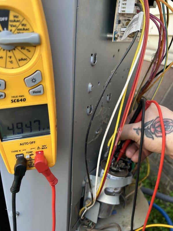 Completed preventative maintenance tune-up on heat pump/air conditioning system located in attic. Performed comprehensive electrical diagnostics using digital multimeter to verify proper voltage readings and system performance, measuring approximately 404.7V and 4.160V at various connection points. Inspected and tested all electrical components including wiring connections, terminal blocks, and capacitor to ensure safe and efficient operation per manufacturer specifications.