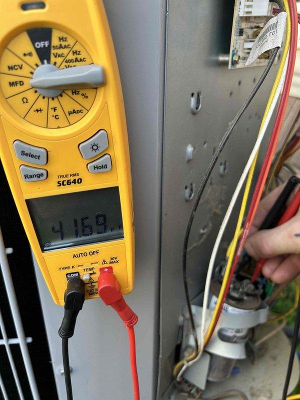 Completed preventative maintenance tune-up on heat pump/air conditioning system located in attic. Performed comprehensive electrical diagnostics using digital multimeter to verify proper voltage readings and system performance, measuring approximately 404.7V and 4.160V at various connection points. Inspected and tested all electrical components including wiring connections, terminal blocks, and capacitor to ensure safe and efficient operation per manufacturer specifications.