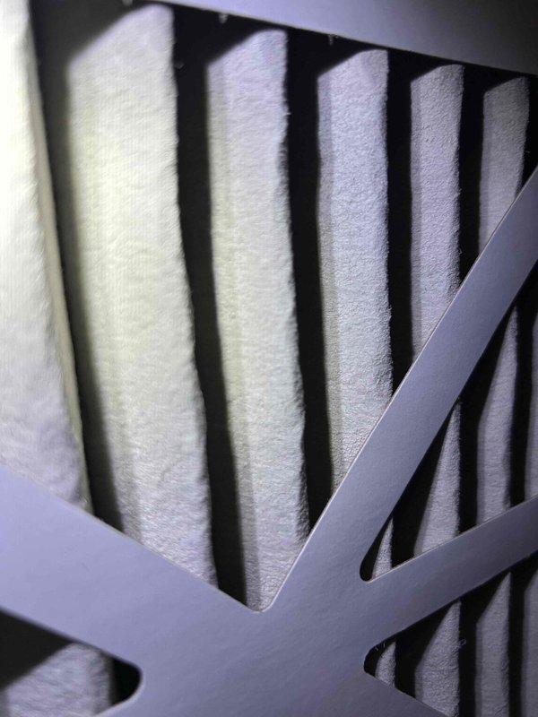 Responded to a no cooling complaint on a 13-year-old electric HVAC system with the indoor unit located in the attic. Upon arrival, thermostat displayed 74°F with system calling for cooling but inadequate temperature reduction reported over the past couple days. Inspected air filter behind return grille, which appeared clean with intact pleated media, though customer was unable to confirm last replacement date.