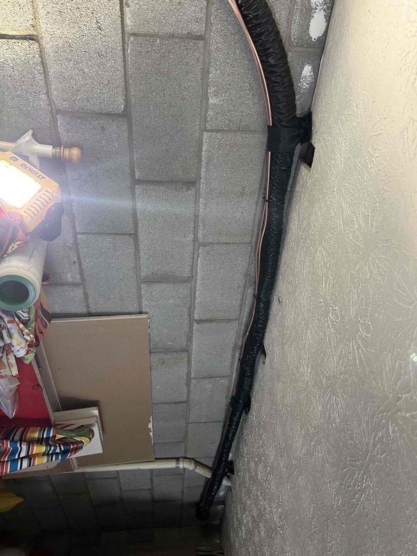 Completed full residential HVAC system replacement with installation of RUUD 14.3 SEER2 3-ton two-stage heat pump (model RP14AY36AJ2NA), RUUD 3-ton air handler (model RH2TY3617STANNJ), and RUUD 15KW heat kit (model RXBH-1724A15J-B). Ran new copper refrigerant line set exposed along back garage wall through penetration to outdoor unit location, secured with appropriate mounting brackets and fully insulated. Installed outdoor unit on new equipment pad with snow legs, electrical disconnect box, and electrical whip connection. Mounted air handler in basement with new insulated supply transition duct connecting to existing ductwork. Enlarged basement return air grille to 14x14 dimensions for improved airflow performance. Installed condensate drain system with trap, SS2 coil drain safety water sensor, and ceiling saver overflow drain pan equipped with secondary water sensor for leak protection. Integrated existing thermostat with new two-stage heat pump system. Installed refrigerant line fil