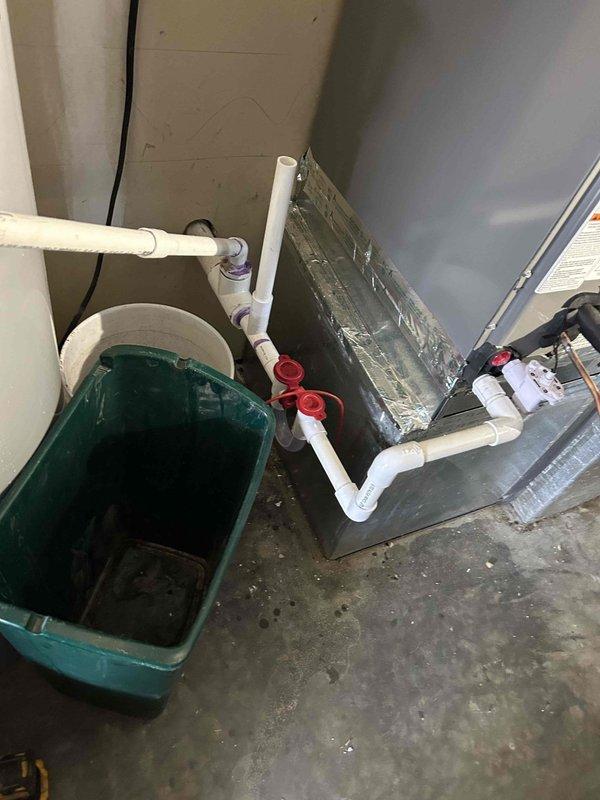 Completed full residential HVAC system replacement with installation of RUUD 14.3 SEER2 3-ton two-stage heat pump (model RP14AY36AJ2NA), RUUD 3-ton air handler (model RH2TY3617STANNJ), and RUUD 15KW heat kit (model RXBH-1724A15J-B). Ran new copper refrigerant line set exposed along back garage wall through penetration to outdoor unit location, secured with appropriate mounting brackets and fully insulated. Installed outdoor unit on new equipment pad with snow legs, electrical disconnect box, and electrical whip connection. Mounted air handler in basement with new insulated supply transition duct connecting to existing ductwork. Enlarged basement return air grille to 14x14 dimensions for improved airflow performance. Installed condensate drain system with trap, SS2 coil drain safety water sensor, and ceiling saver overflow drain pan equipped with secondary water sensor for leak protection. Integrated existing thermostat with new two-stage heat pump system. Installed refrigerant line fil