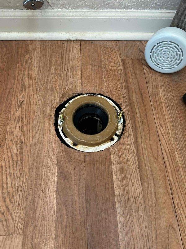 Responded to callback for toilet leak two months post-installation. Inspection revealed compromised wax ring seal at floor flange connection. Removed toilet, replaced wax ring and closet bolts, reinstalled and tested unit to confirm proper seal with no active leaks detected.