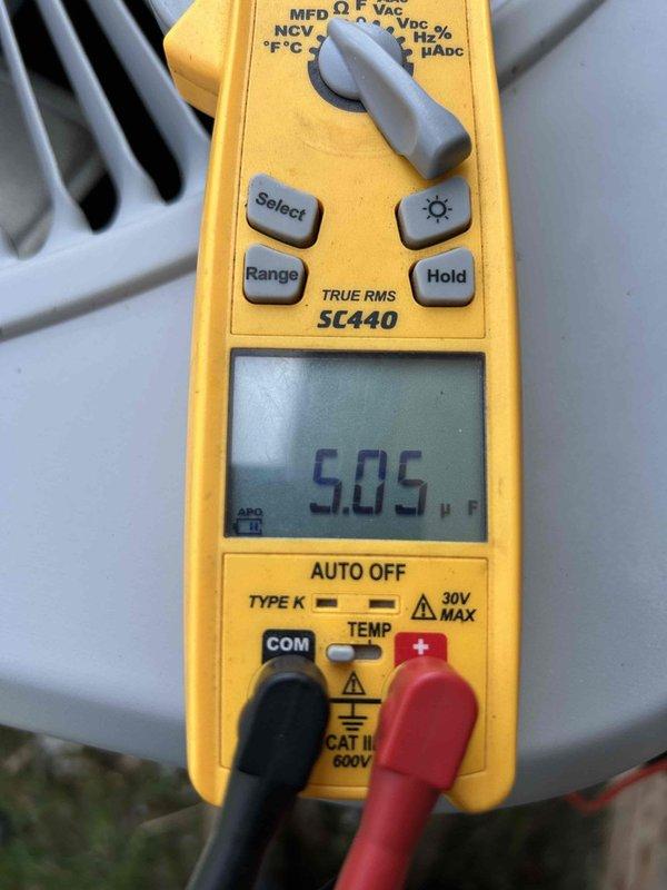 Completed comprehensive Care Plan tune-up on heat pump and air handler system located in garage. Performed electrical diagnostics using digital multimeter, measuring capacitance at 5.05 μF and verifying system amperage at 0.63A with 0.1V readings to ensure proper compressor and motor operation. All components tested within manufacturer specifications and system operating efficiently.