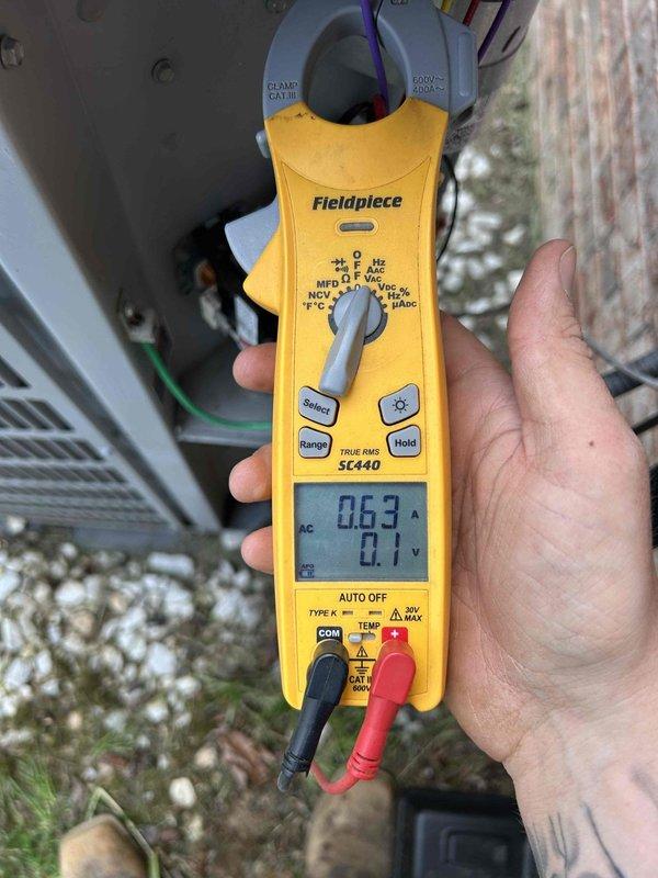Completed comprehensive Care Plan tune-up on heat pump and air handler system located in garage. Performed electrical diagnostics using digital multimeter, measuring capacitance at 5.05 μF and verifying system amperage at 0.63A with 0.1V readings to ensure proper compressor and motor operation. All components tested within manufacturer specifications and system operating efficiently.