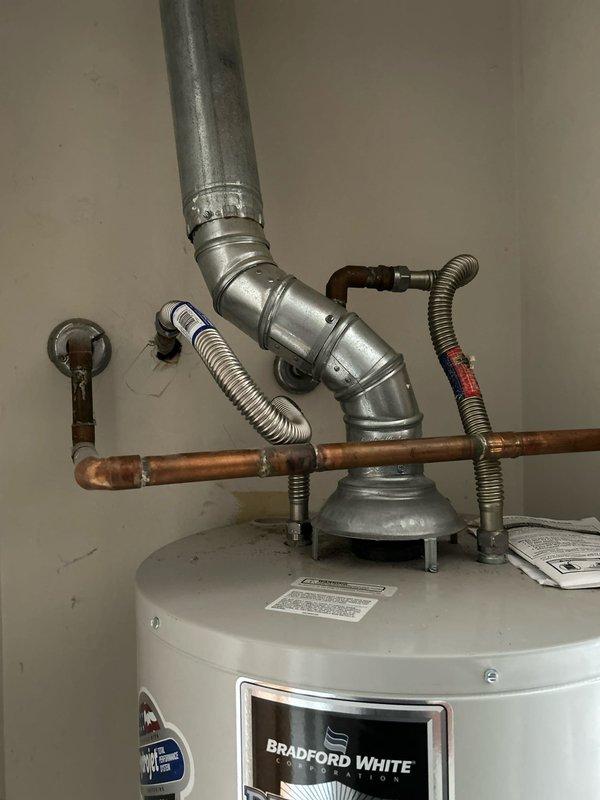 Performed comprehensive maintenance service on Bradford White 40-gallon natural gas water heater, model RG240T6N. Completed full tank drain and flush to remove sediment buildup, as unit had never received previous maintenance despite being in working condition. Inspected and evaluated anode rod condition for potential replacement needs. Examined venting system extending into attic area and assessed condition of vent connector and proper clearance specifications. Verified all plumbing connections, including copper supply lines and flexible gas line connections, for proper operation. Unit operational upon completion of maintenance service.