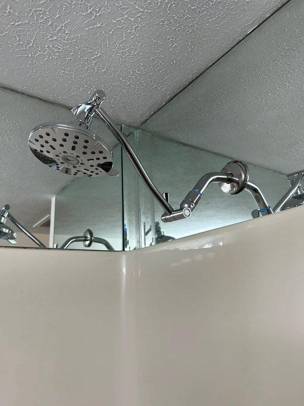 Completed installation of customer-supplied fixtures including a chrome shower head with adjustable curved arm mounted to existing shower plumbing, a two-handle chrome faucet with porcelain caps installed at bathroom vanity sink, and washing machine hookup. Performed leak inspection of all toilets on property to verify proper seal and flush valve operation, with no leaks detected.