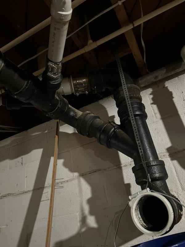 Responded to a main drain blockage causing toilet backup into shower. Accessed main drain cleanout in basement utility area and cleared obstruction in the primary waste line. Verified proper drainage flow through the system, restoring normal function to affected fixtures.