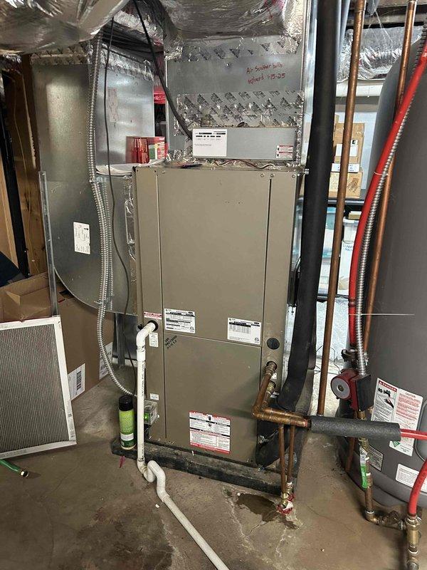 # HVAC Service Call - Geothermal System No Airflow

Responded to no cooling complaint on 11-year-old geothermal heat pump system. Customer reported unit humming but no air coming from vents. Upon arrival, confirmed geothermal unit was running but air handler blower was not operating.

**Diagnostic Findings:**

Inspected air handler and evaporator coil assembly in basement mechanical room. Observed significant corrosion on metal housing panels along evaporator coil cabinet edges. Checked electrical connections at blower motor and verified power supply to unit. Tested blower motor capacitor and found failed capacitor preventing blower motor from starting. Motor was attempting to run (humming sound) but could not overcome starting torque without functional capacitor.

Examined overall system condition during inspection. Noted age-related deterioration including rust on cabinet panels and moisture staining on base pan beneath evaporator coil. Refrigerant lines and insulation appeared intac