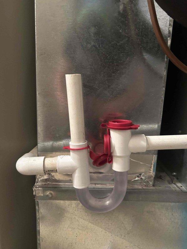 Responded to water leak complaint on recently installed Ruud 14.3 SEER 2-stage heat pump system. Upon inspection, identified leaking condensate drain trap assembly with compromised seal at PVC connection point. Disassembled drain trap, cleaned components, resealed connections with appropriate primer and cement, and reassembled drainage system. Verified proper trap configuration and tested system operation to confirm leak resolution with no further water accumulation observed.