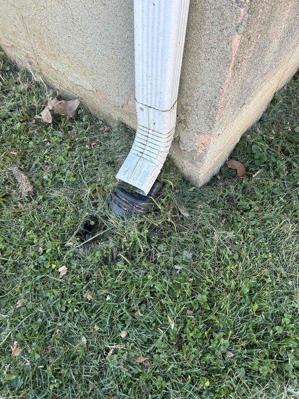 Responded to service call regarding chemical odor in bedroom during air conditioning operation. Upon inspection, discovered condensate pump in crawl space with standing water accumulation on concrete floor, indicating drainage issues. Examined exterior drainage system and downspout configuration at foundation level. Chemical smell determined to be related to stagnant water in condensate system causing biological growth and odor transmission through HVAC ductwork. Documented moisture conditions and drainage components for recommended corrective action.