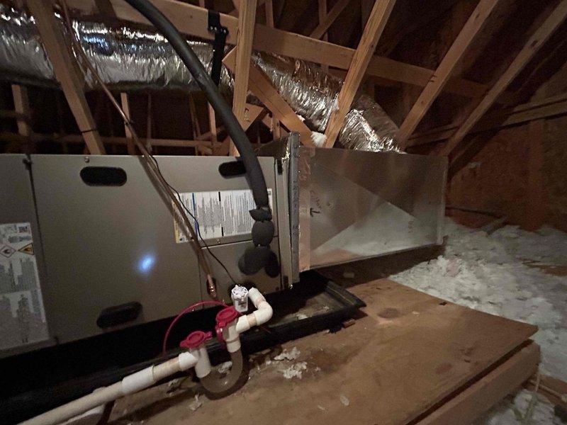 Completed full residential HVAC system installation including Bryant 2.5 ton 14.3 SEER2 heat pump (model GH5SAN53000A), Bryant air handler (model FJ5ANXB36L00) installed in attic space, and Bryant 10 KW heat kit (model TU-EC-10BKB). Positioned outdoor condenser unit on mounting pad with snow legs adjacent to home foundation, installed electrical disconnect box and whip kit with conduit run up exterior wall. Mounted air handler in attic with proper platform support over insulation, connected flexible ductwork to existing distribution system, and installed PVC condensate drain line with trap. Integrated existing thermostat with new system, installed insulated refrigerant lines between outdoor and indoor units, and added refrigerant line filter. Completed all electrical connections to code, obtained necessary permits, pressure tested refrigerant system, evacuated lines, charged system to manufacturer specifications, and verified proper operation of heating and cooling modes. Removed and d