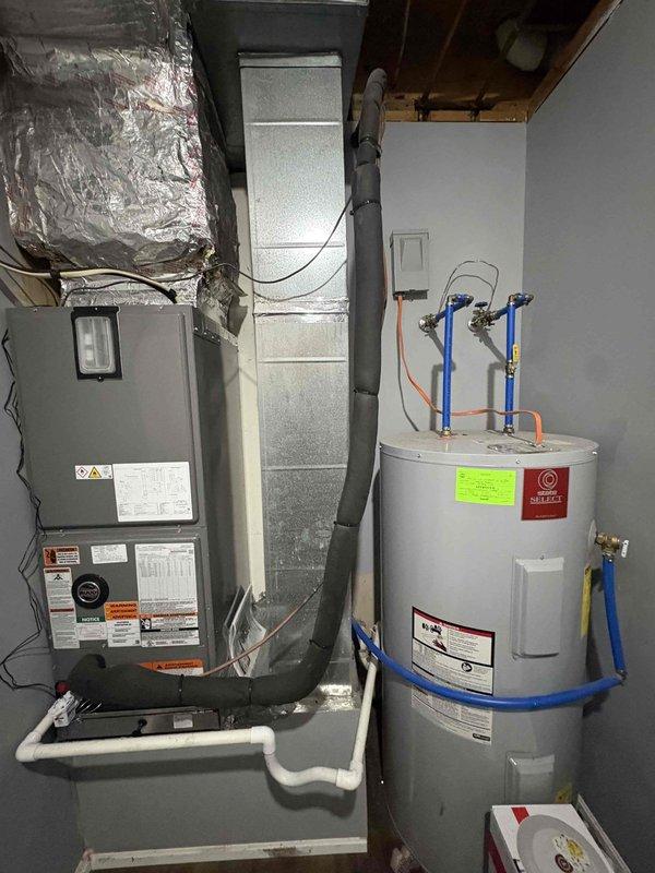 Completed full residential HVAC system installation featuring a RUUD 14.3 SEER2 2.5-ton two-stage heat pump (model RP14AY30AJ2NA) with matching 3-ton air handler (model RH2TY3617STANNJ) and 15KW heat kit (model RXBH-1724A15J-B). Removed and properly disposed of existing equipment, then installed outdoor unit on new pad with snow legs, electrical disconnect box, and whip kit. Installed air handler in mechanical room with refrigerant line insulation, refrigerant line filter, and transitions to existing ductwork. Added SS2 coil drain safety water sensor with trap and standard-sized air filter rack. Installed digital WiFi thermostat for system control. Completed all electrical connections with conduit and wiring per code requirements. Pulled applicable permits, performed system startup, tested all operations including two-stage heating and cooling functions, verified proper refrigerant charge, and confirmed thermostat programming and WiFi connectivity. System operating within manufacturer 