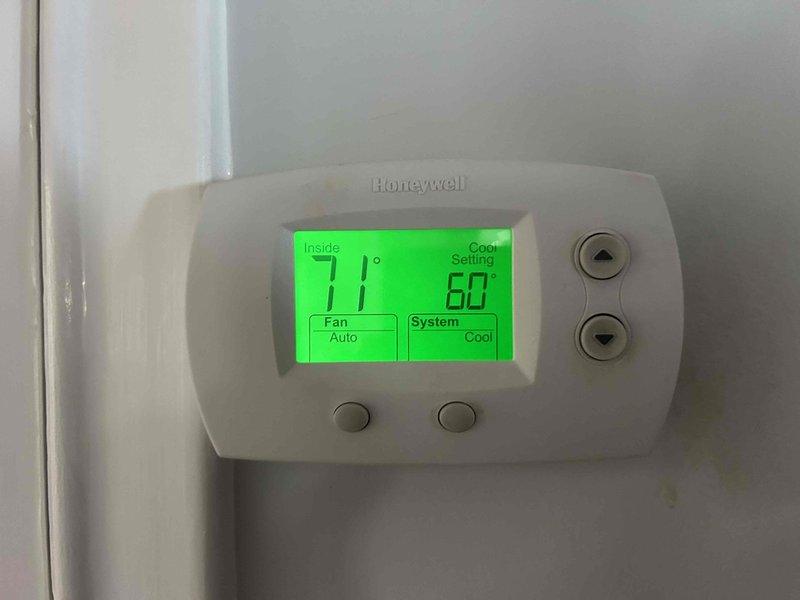 Responded to no heat complaint on 12-year-old gas furnace system with uneven heating in two rooms. Upon arrival, inspected Honeywell thermostat showing 71°F indoor temperature with system set to cooling mode at 60°F. Proceeded to outdoor condensing unit to perform electrical diagnostics on air conditioning system as requested. Measured voltage at capacitor terminals using multimeter, recording 113V at the component. Inspected electrical connections including multiple wire terminations at capacitor and reviewed system specifications on equipment panel. Evaluated ductwork concerns related to uneven heat distribution in affected rooms and assessed overall system operation for both heating and cooling functions.