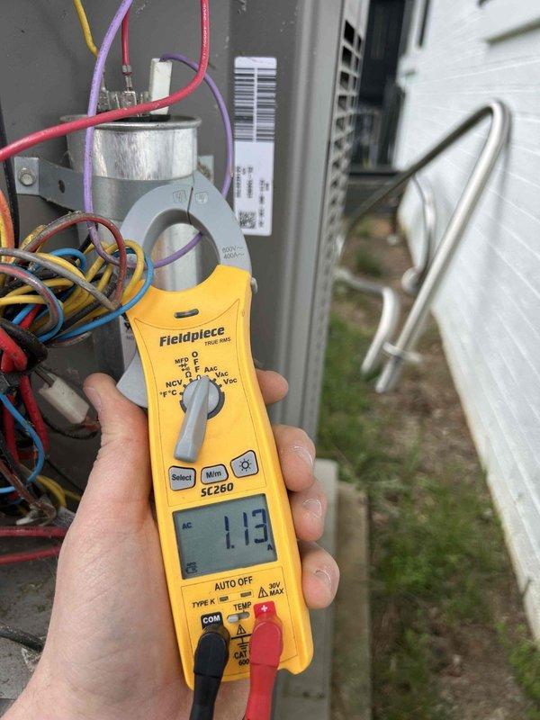 Responded to no heat complaint on 12-year-old gas furnace system with uneven heating in two rooms. Upon arrival, inspected Honeywell thermostat showing 71°F indoor temperature with system set to cooling mode at 60°F. Proceeded to outdoor condensing unit to perform electrical diagnostics on air conditioning system as requested. Measured voltage at capacitor terminals using multimeter, recording 113V at the component. Inspected electrical connections including multiple wire terminations at capacitor and reviewed system specifications on equipment panel. Evaluated ductwork concerns related to uneven heat distribution in affected rooms and assessed overall system operation for both heating and cooling functions.