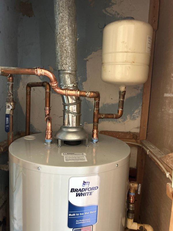 Installed a new Bradford White 40-gallon gas water heater with proper copper piping connections, expansion tank, and venting system. The installation included connecting hot and cold water lines with shutoff valves, securing the flue pipe for proper exhaust ventilation, and ensuring all connections meet code requirements. Unit was tested and verified operational upon completion.