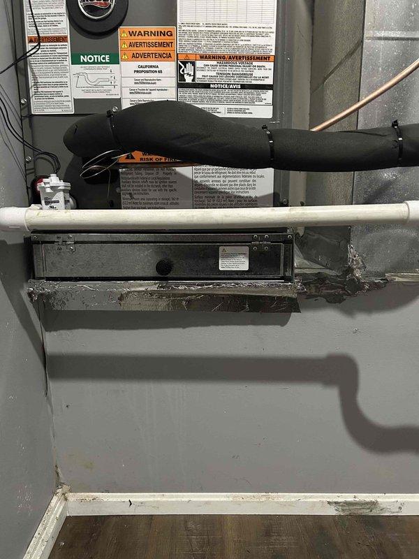Responded to no heat call where system and thermostat were unresponsive. Upon inspection, discovered severely corroded condensate drain fitting and metal components with heavy rust buildup affecting system operation. Documented existing HVAC unit installation and corroded plumbing connections for warranty callback assessment.