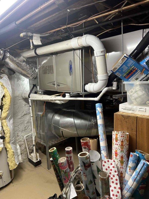 Completed annual AC tune-up on 15-year-old Carrier heat pump system with Infinity Touch thermostat. Performed comprehensive maintenance including inspection of air handler unit located in basement, verified system operation in stage 2 cooling mode with 1050 CFM airflow and 1018 RPM blower speed, confirmed 239V line voltage and proper outdoor coil temperature at 48°F. Replaced 16x25x4 filter included in maintenance plan, inspected PVC condensate drainage, checked refrigerant lines and ductwork connections, and verified thermostat programming and communication with heat pump system.