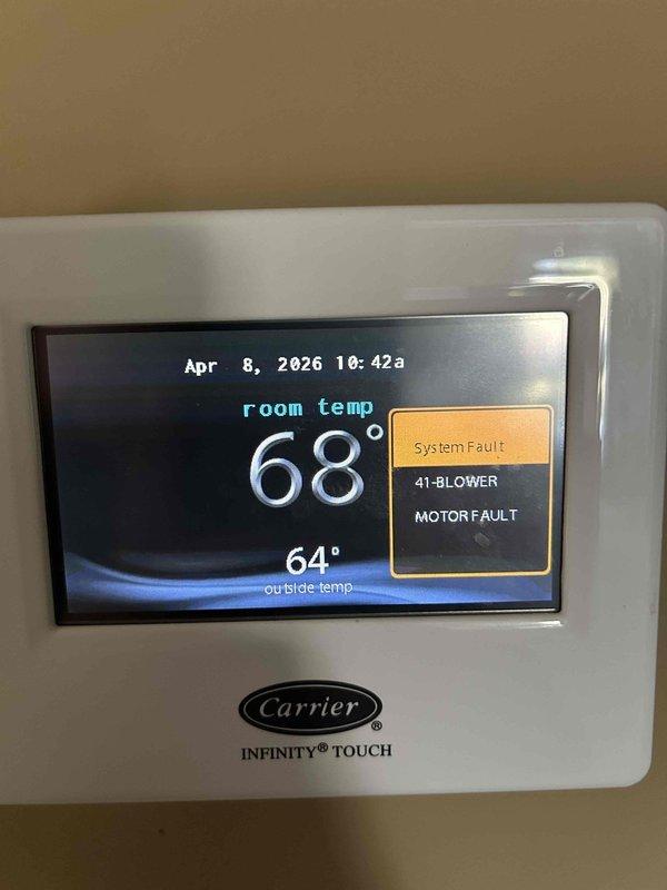 Responded to no cooling complaint on dual-zone residential system with 11-year-old attic unit and 5-year-old basement unit. Diagnosed blower motor fault (error code 41) on attic Carrier Infinity system as indicated by thermostat display showing "System Fault - Blower Motor Fault" with indoor temperature at 68°F and outdoor temperature at 64°F. Inspected air handler unit in attic installation and confirmed blower motor failure preventing airflow and cooling operation. Advised customer of blower motor replacement requirement to restore cooling function to attic zone. Additionally noted basement system requires humidifier pad replacement for proper humidity control.